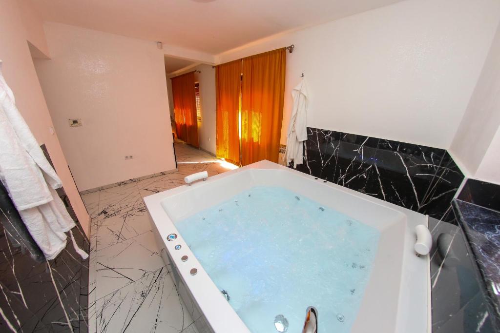 a bathroom with a jacuzzi tub in a room at Hedonist Spa Jacuzzi Sarajevo in Sarajevo