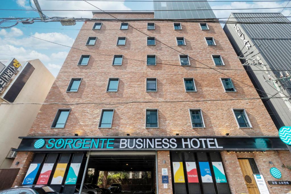 Sorgente Business Hotel في بوسان: مبنى من الطوب كبير عليه لافته