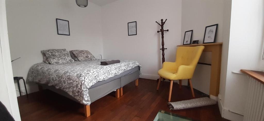 a bedroom with a bed and a yellow chair at Ker Karantez in Rennes