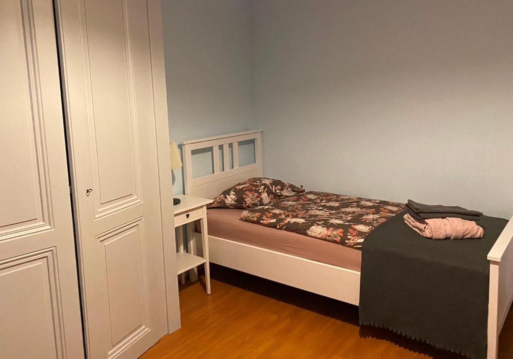 een kleine slaapkamer met een bed en een bureau bij Pension Bienvenue (Women only) in Lausanne