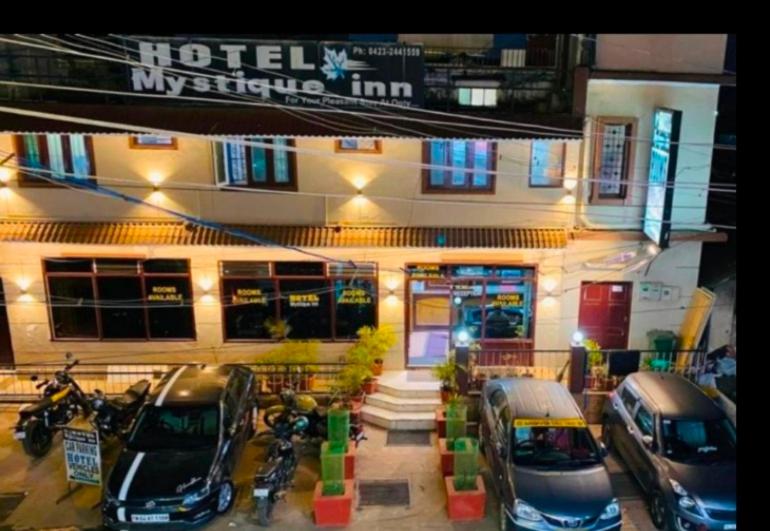 zwei Autos, die vor einem Hotel geparkt sind in der Unterkunft Hotel mystique inn ooty in Udagamandalam