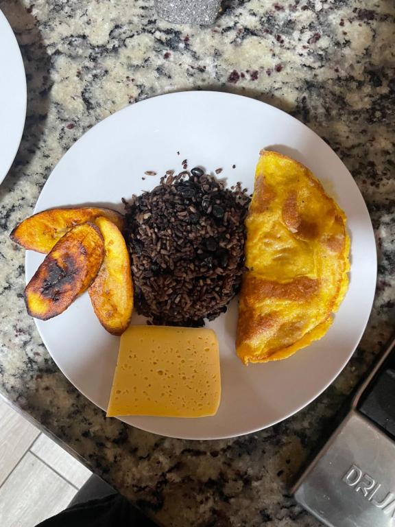 un plato blanco con alimentos para el desayuno en una barra en Glamping Campo Alegre, en Cartago