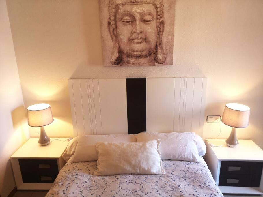 ein Schlafzimmer mit einer Statue eines Gesichts über einem Bett in der Unterkunft Apartamento con la playa a 200 metros in Granada