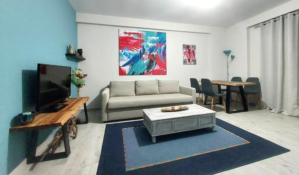 sala de estar con sofá, TV y mesa en Apartment, en Ioannina