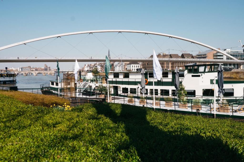 un pont sur une rivière avec des bateaux sur l'eau dans l'établissement Botel Maastricht, à Maastricht