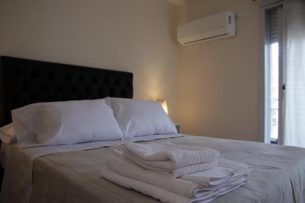 a bed with white towels sitting on top of it at Malanca - Nueva Córdoba in Cordoba