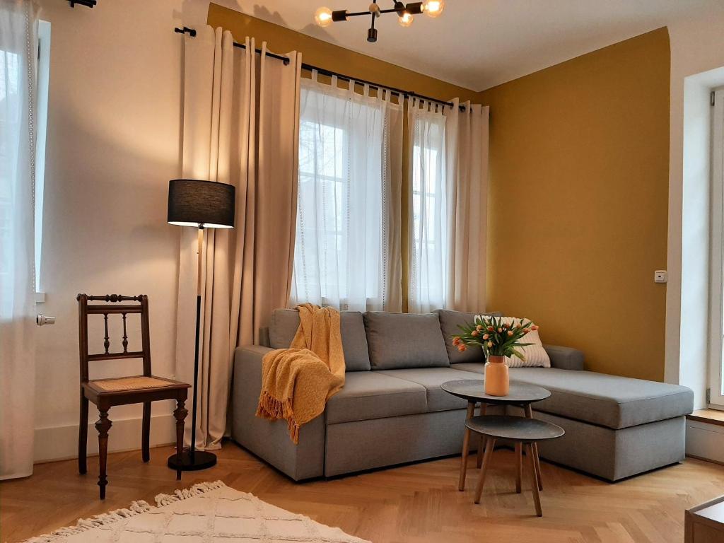 salon z kanapą i stołem w obiekcie Apartment 4-6 Personen I 80qm I Altstadt I Dachterasse I Parkplatz w mieście Straubing