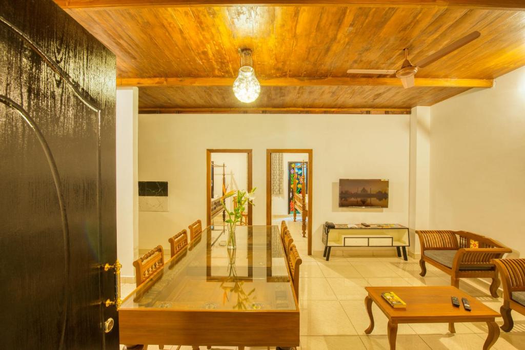 uma sala de estar com mesa e cadeiras em La Maison Charu em Pondicherry