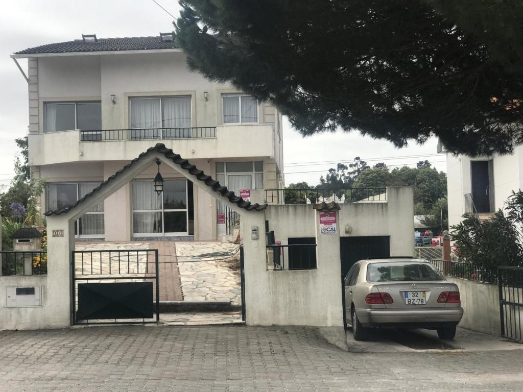 um carro estacionado em frente a uma casa branca em Joe's House em Fátima