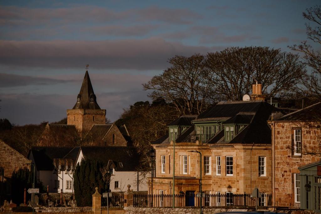 un vecchio edificio in mattoni con una torre e una chiesa di Links House at Royal Dornoch a Dornoch