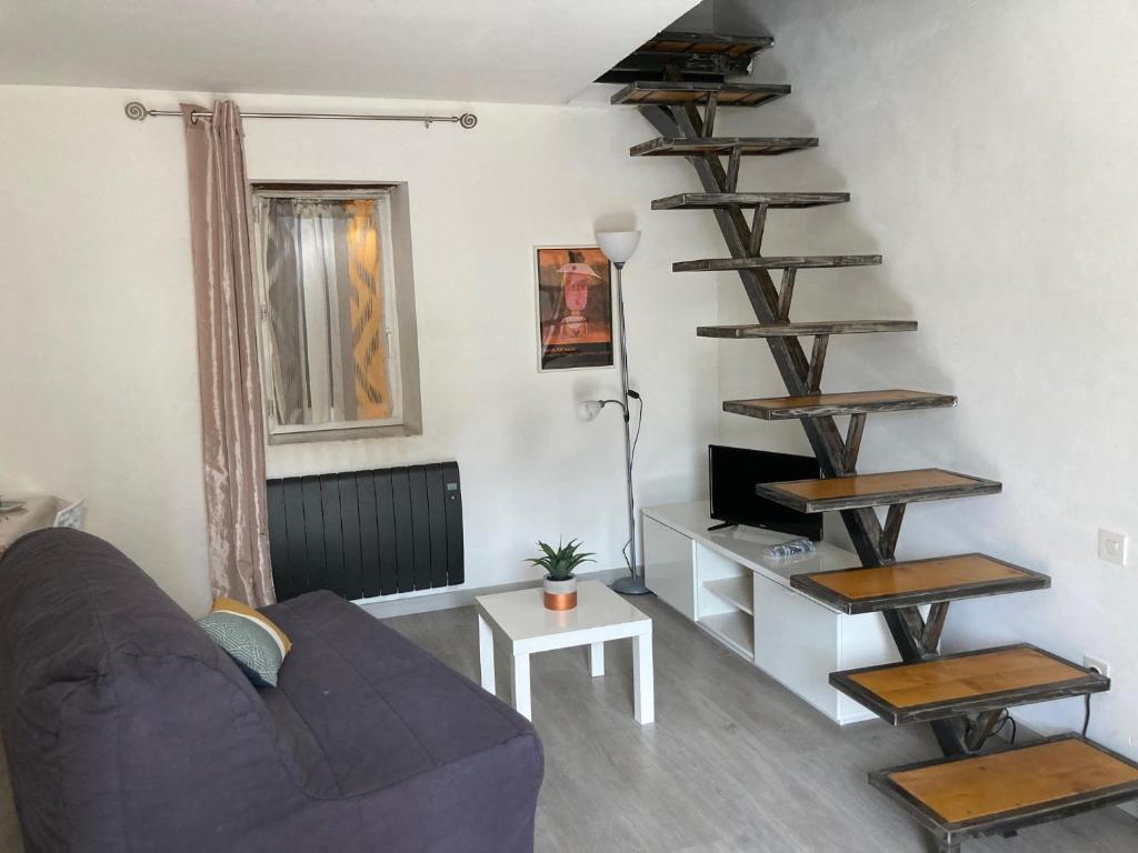 een woonkamer met een bank en een wenteltrap bij Maison Kyprea: charmant appartement /duplex , spacieux, tout confort avec terrasse extérieure privée, parking privatif , vue pittoresque sur la citadelle de Corté et les montagnes. in Corte