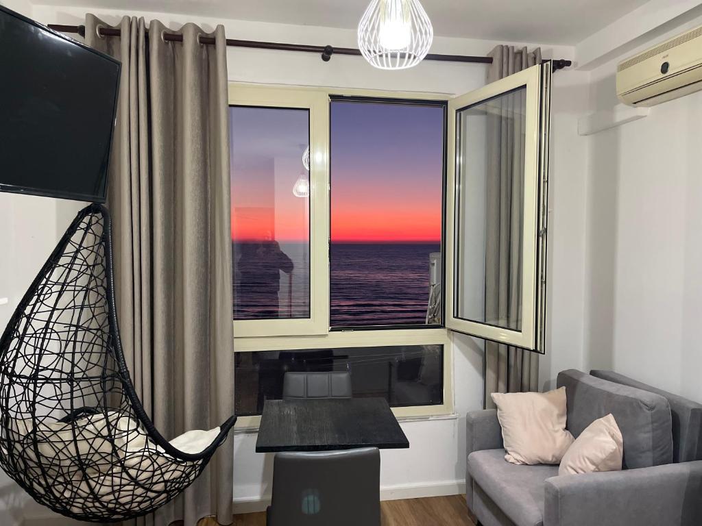 - un salon avec une chaise et une vue sur l'océan dans l'établissement Arteg Apartments - Full Sea View, à Durrës