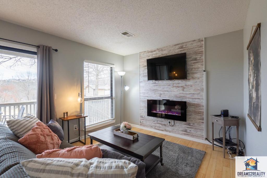 - un salon avec un canapé et une télévision sur un mur en briques dans l'établissement 1BR Walk-In Condo at Pointe Royal - 2 Pools - FREE ATTRACTION TICKETS INCLUDED -PR42-16, à Branson