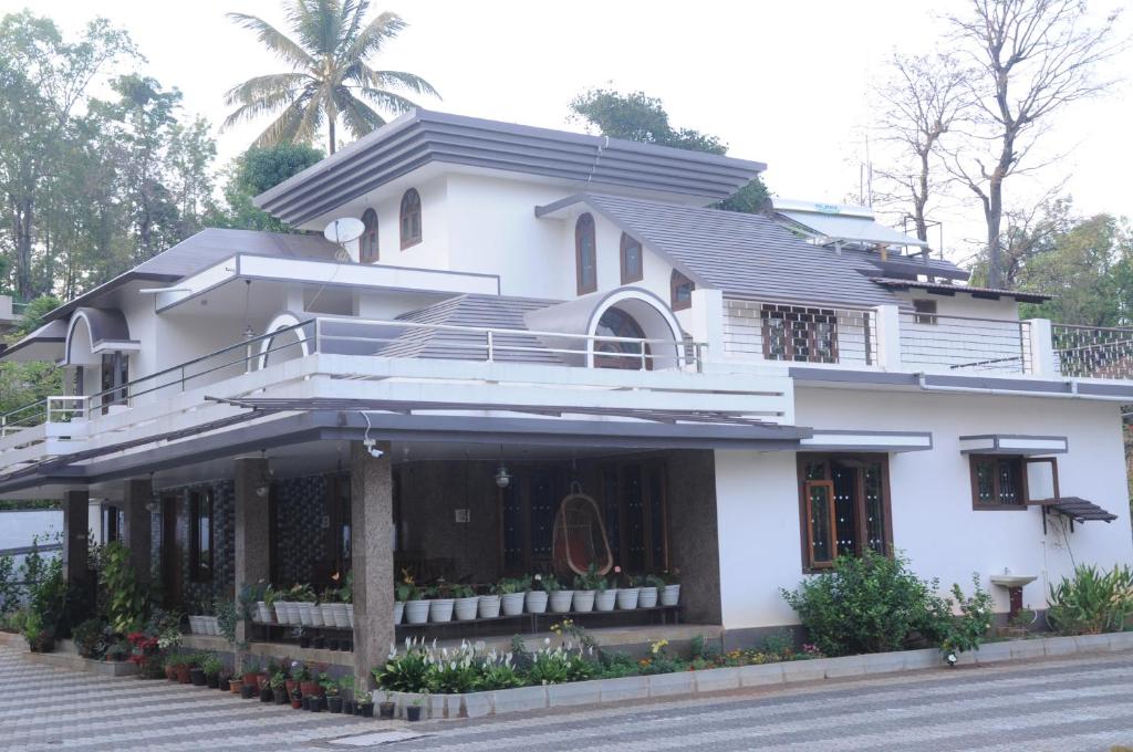 una casa bianca sul lato di una strada di Misty Retreat (Pragati House) a Madikeri