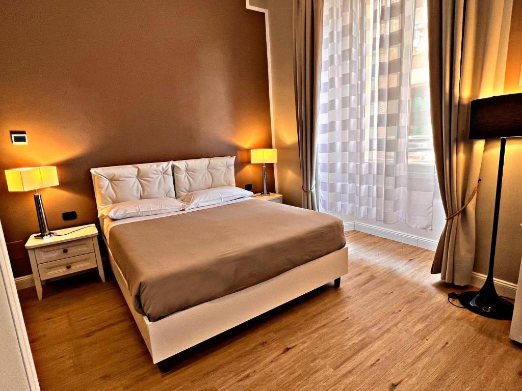 um quarto com uma cama com 2 candeeiros e uma janela em Fabio Massimo Guest House em Roma