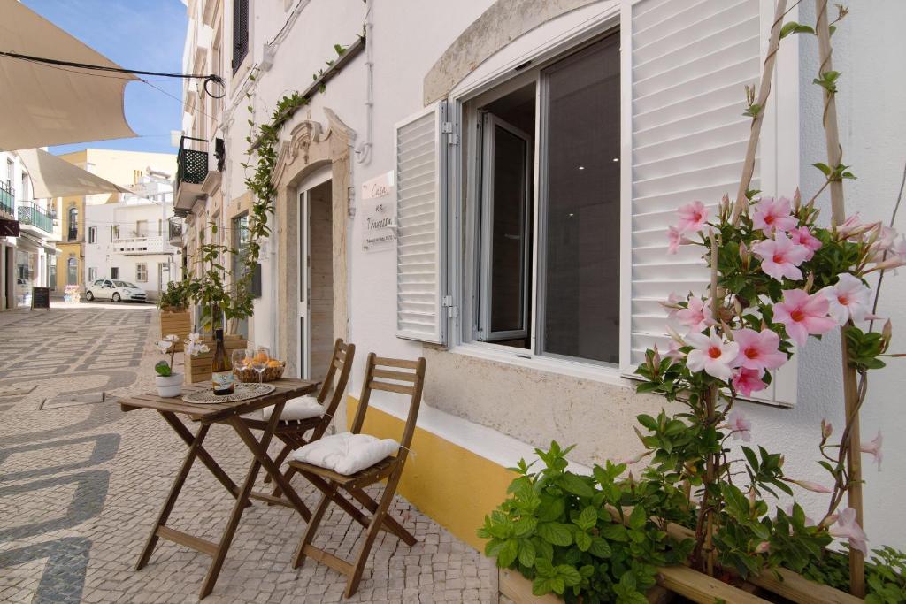 uma mesa e cadeiras ao lado de um edifício com flores em Casa na Travessa 2 em Faro