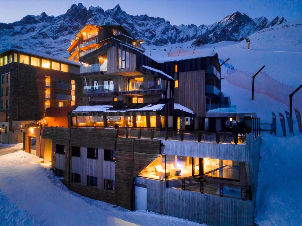 um edifício na neve à noite com neve em Bergman Mountain Hotel em Breuil-Cervinia