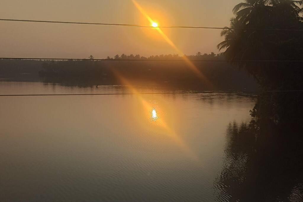 un lever de soleil sur une étendue d'eau et un coucher de soleil dans l'établissement Ocean Pearl, à Kozhikode