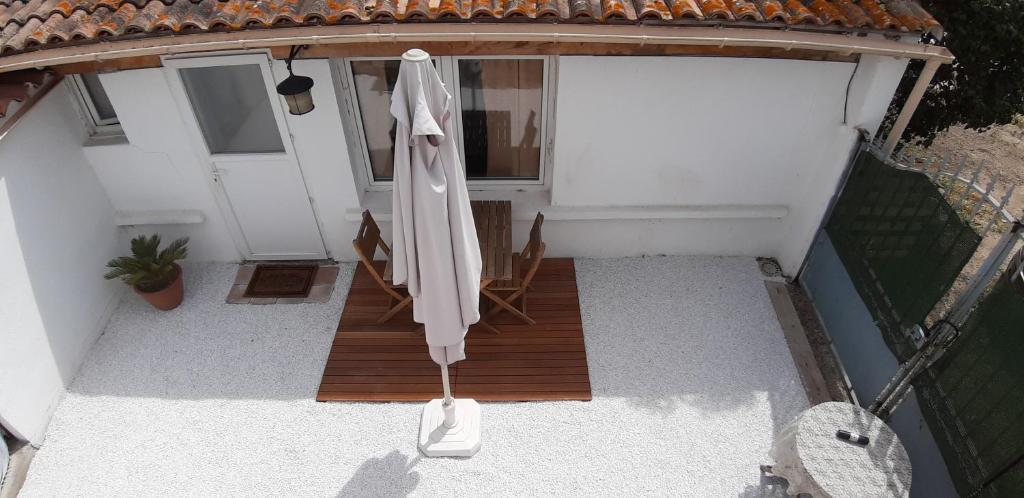 einen offenen Sonnenschirm auf dem Balkon eines Hauses in der Unterkunft petit studio indépendant dans jardin avec parking et portail électrique in Marseille