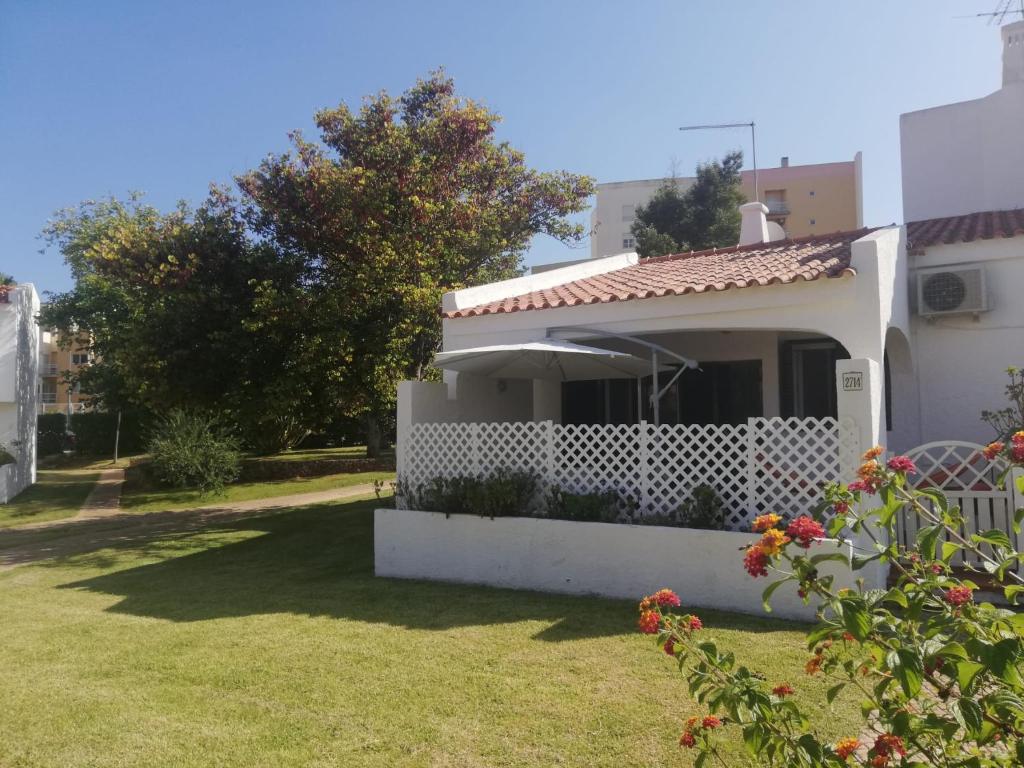 uma pequena casa branca com um jardim de relva em Vilamoura Alecrim em Vilamoura