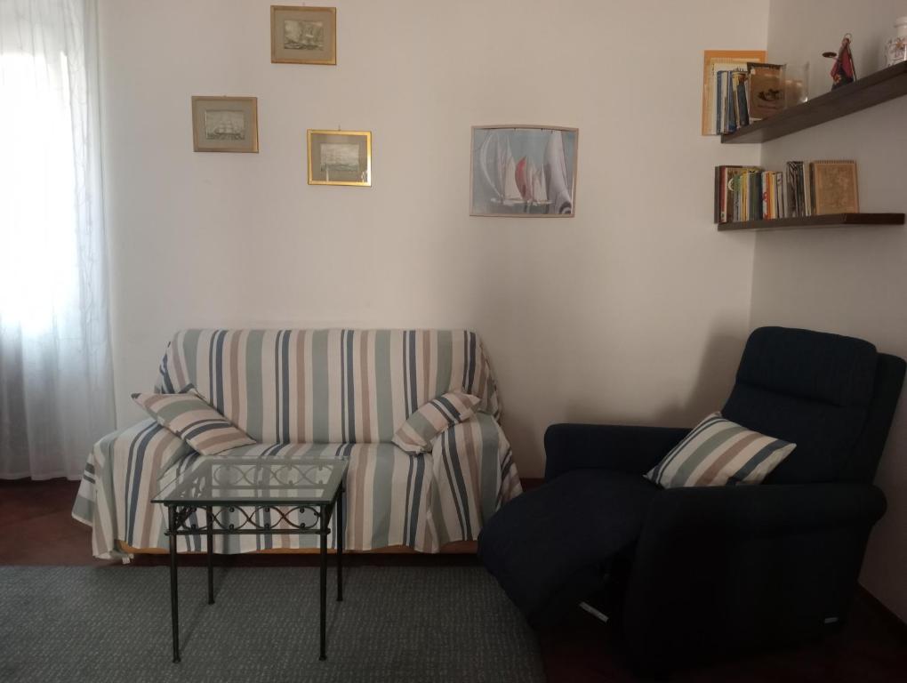 ein Wohnzimmer mit einem Sofa und einem Stuhl in der Unterkunft Casa Azzurra in Orbetello