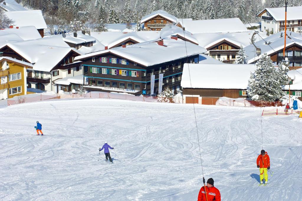 um grupo de pessoas a esquiar numa encosta coberta de neve em Alpin & Wellness Resort Hotel Ludwig Royal em Oberstaufen