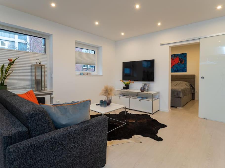 a living room with a couch and a flat screen tv at Traumkoje im Herzen Westerlands strandnah Meer in Westerland (Sylt)