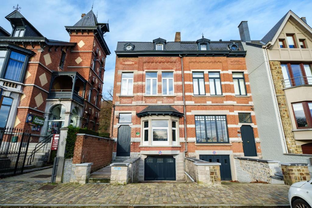 an old brick building with a clock tower on it at à la pointe de l'ile in Namur