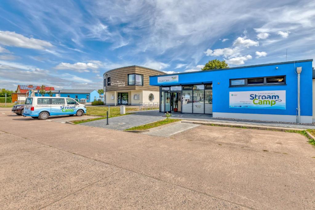 a building with a van parked in a parking lot at StroamCamp Schwedt - a84456 in Schwedt