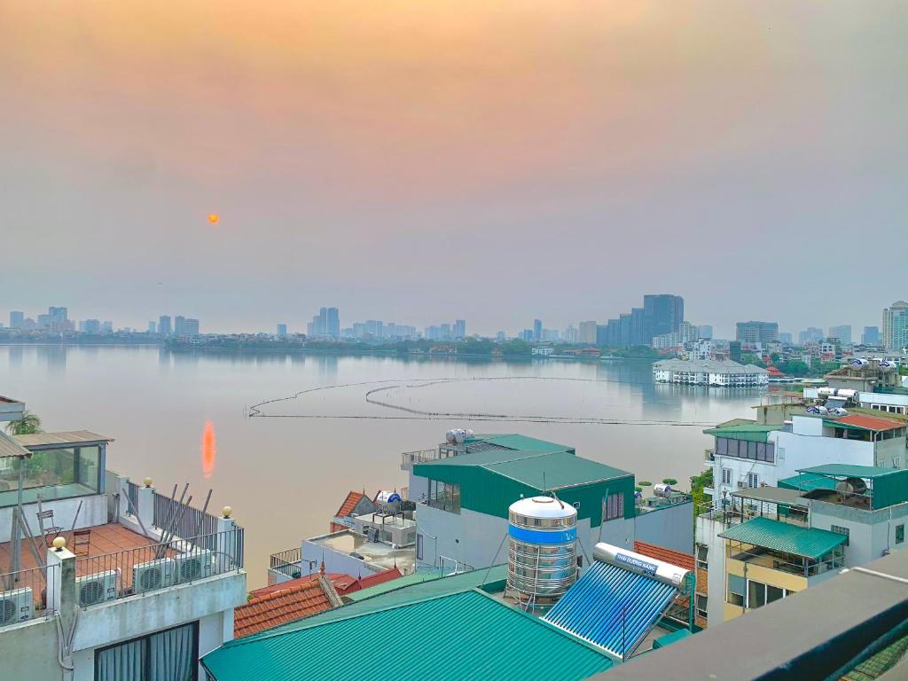 une vue sur une étendue d'eau avec des bâtiments dans l'établissement Homestay Vũ Miên, Tây Hồ, Ba Đình, à Hanoï