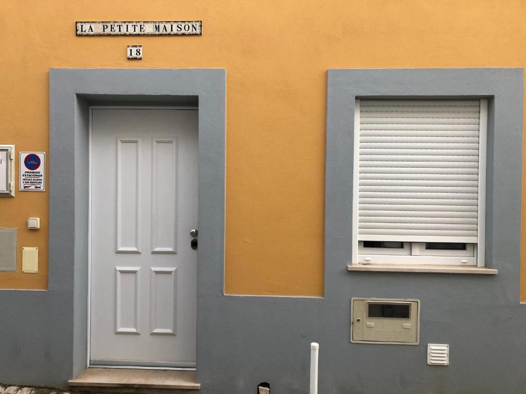 um edifício com uma porta branca e uma janela em La petite maison em Portimão