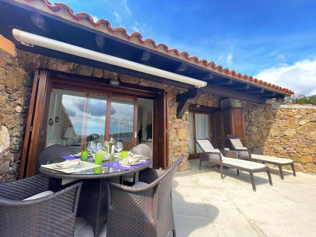 d'une terrasse avec une table et des chaises sur un balcon. dans l'établissement San Teodoro Punta Est Magnifico Trilocale Vista Mare, à Cap Coda Cavallo