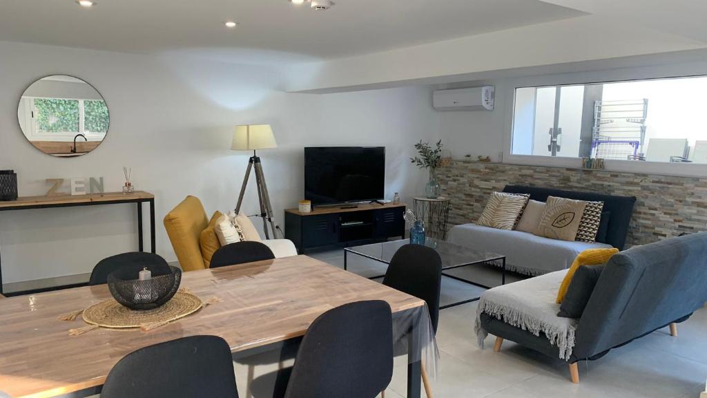 a living room with a table and chairs and a tv at Rodhes Playa B-1 in Roses