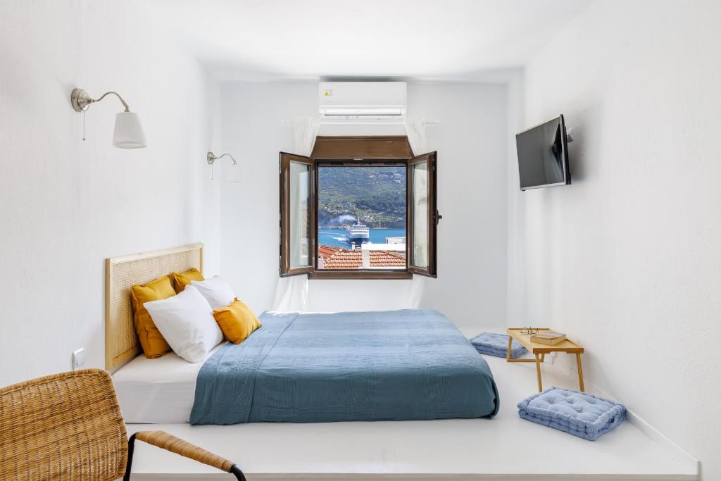 een slaapkamer met een bed en een raam bij Cath's Loft in Skopelos Town