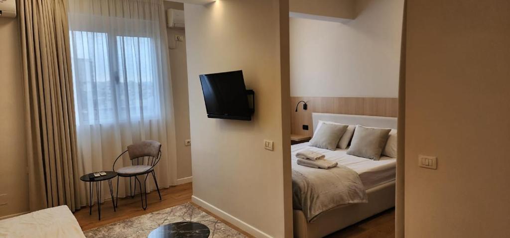 una camera con letto e TV a parete di Signature Idea hotel a Tirana