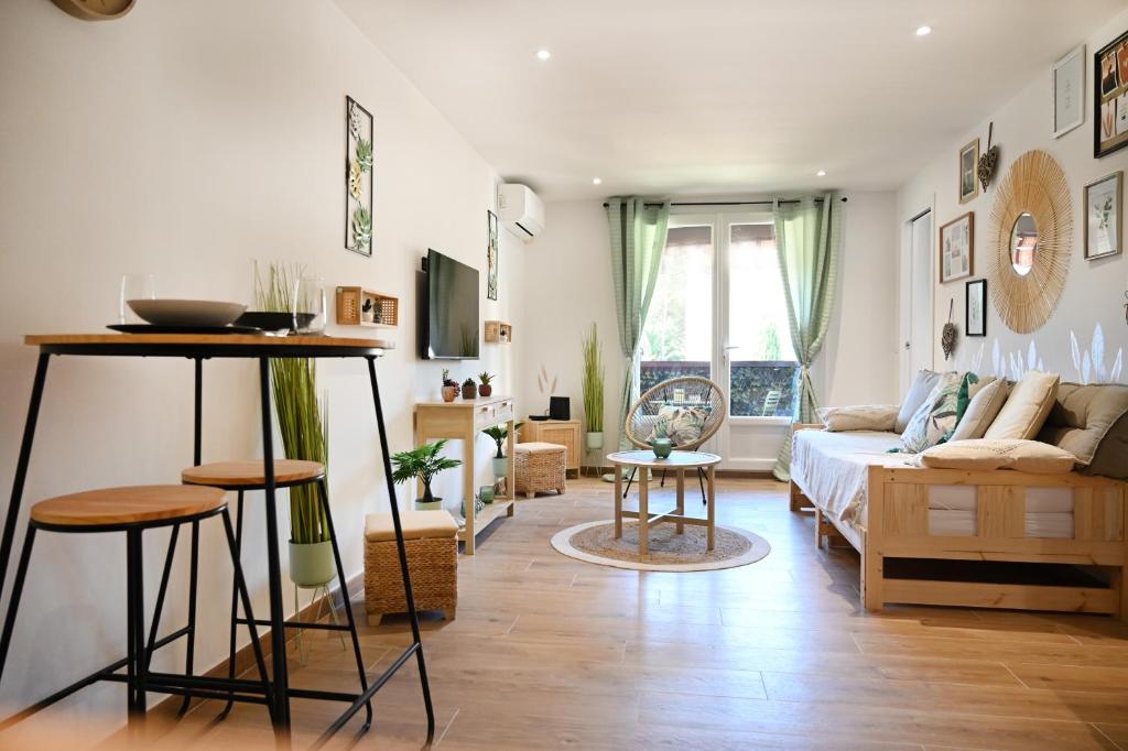 uma sala de estar com um sofá e uma mesa em Appartement Design em Fréjus