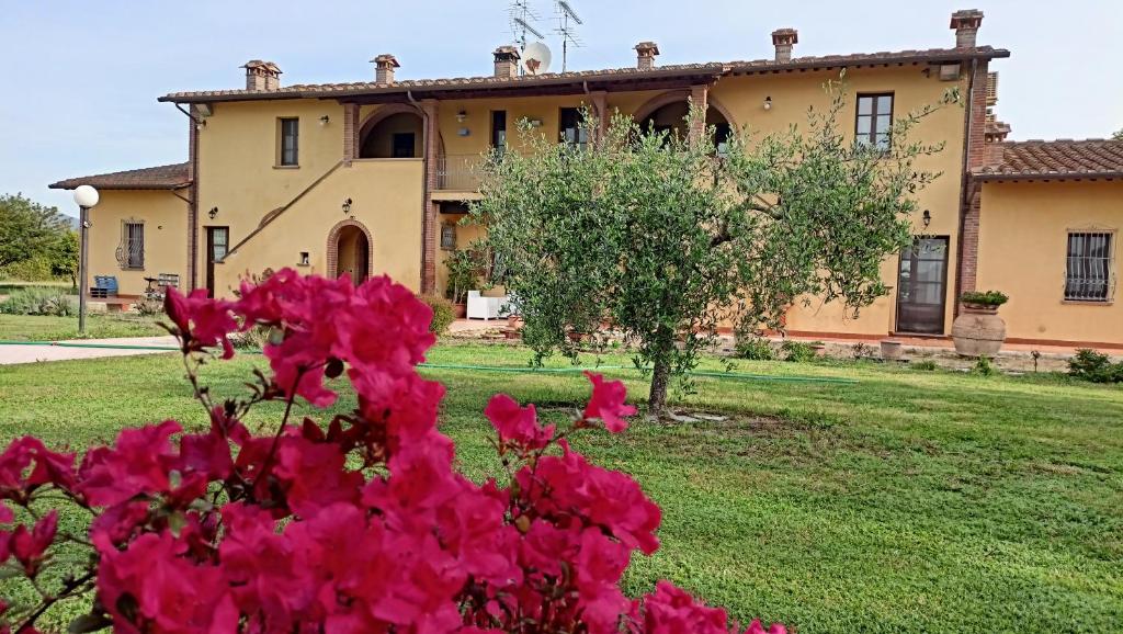 una casa con flores rosas delante de ella en il Chiassetto Agriturismo No Kids, en Cascina