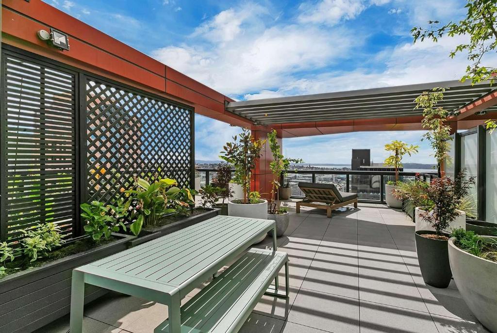 een patio met een bank en planten op een balkon bij City and view holiday home in Auckland