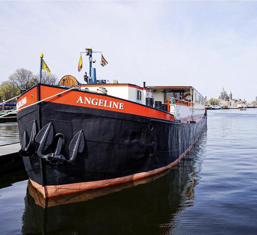 ein großes Boot ist im Wasser angedockt in der Unterkunft Hotelboat Angeline in Amsterdam