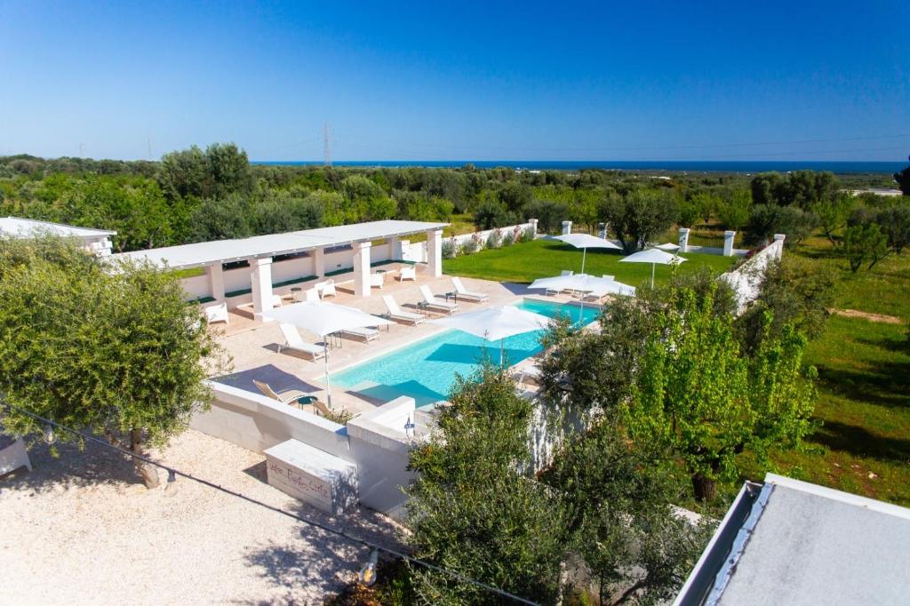 una vista aerea su una piscina con sedie e ombrelloni di Tenuta Amostuni-Country House a Ostuni