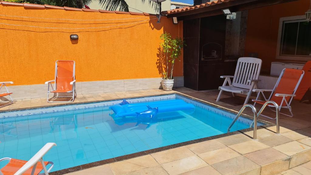 una piccola piscina con sedie e tavolo di Pousada Paraíso das Conchas na praia do Peró Cabo Frio RJ a Cabo Frio