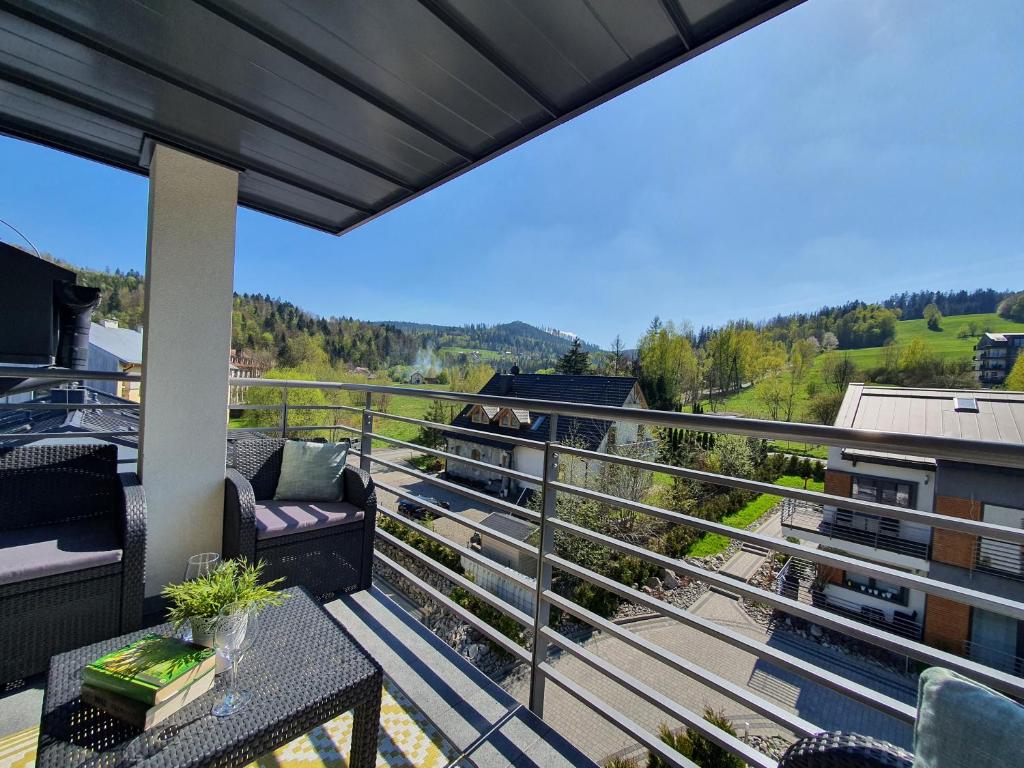 een balkon met stoelen en een tafel en uitzicht bij Apartamenty Ski & Fun Spokojna in Wisła