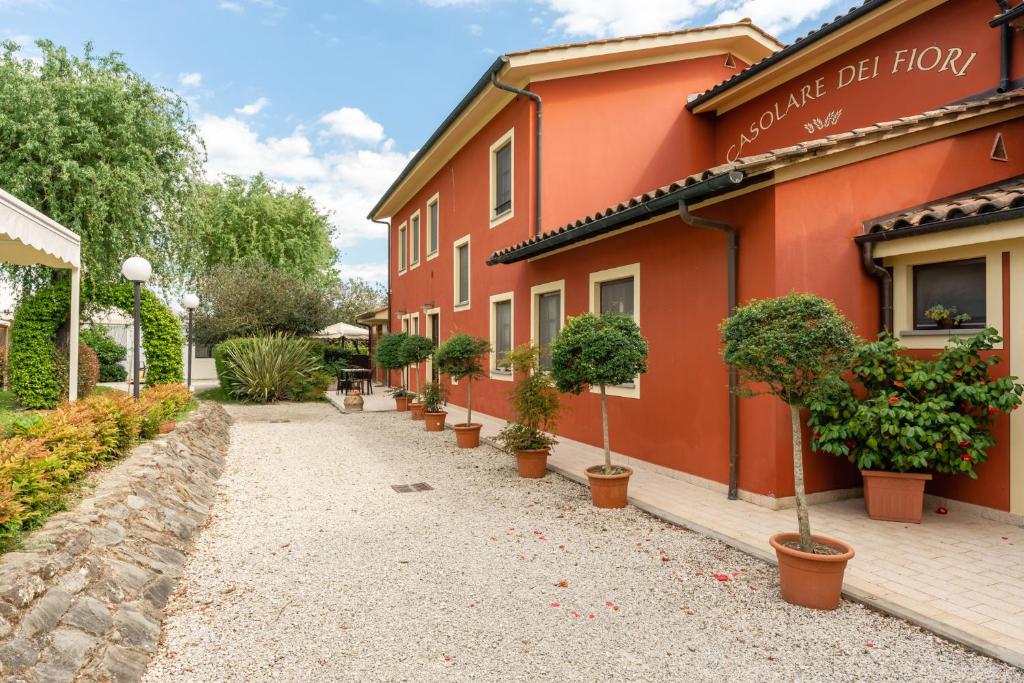 un edificio rojo con macetas delante de él en Casolare dei Fiori - Mughetto, en Montecarlo