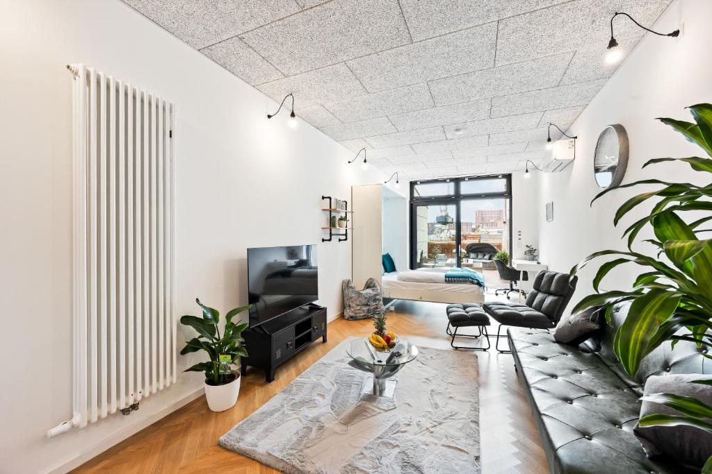 ein Wohnzimmer mit einem Sofa und einem Tisch in der Unterkunft Lit Living - Luxus Loft - Box Spring - Air Con - BBQ - Panorama in Mannheim