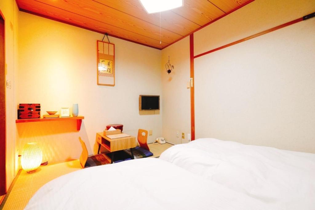 - une chambre avec un lit blanc et une télévision dans l'établissement Nara Ryokan - Vacation STAY 49528v, à Nara