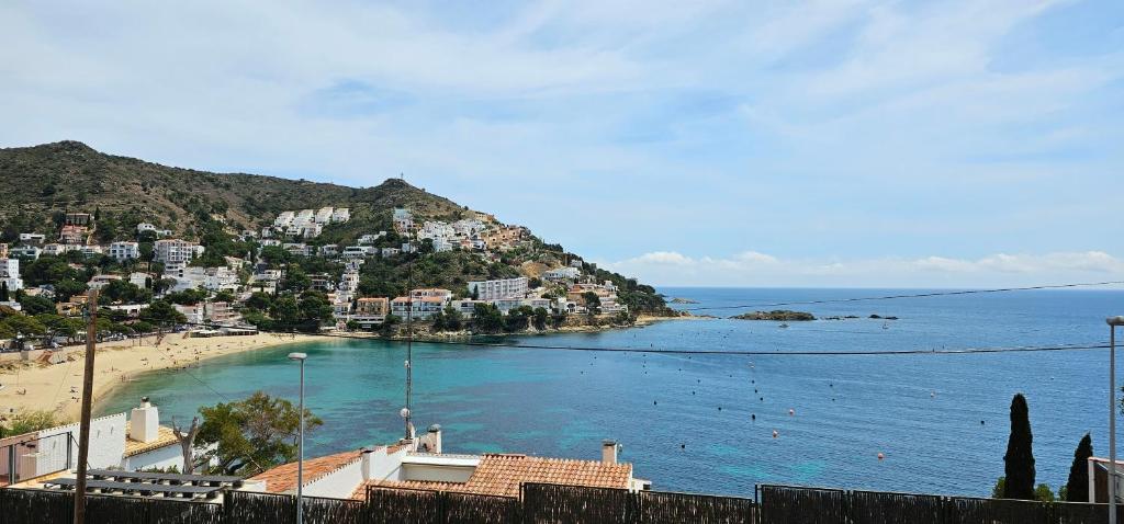 a view of a beach with houses on a hill at Apartamento Canyelles playa in Roses