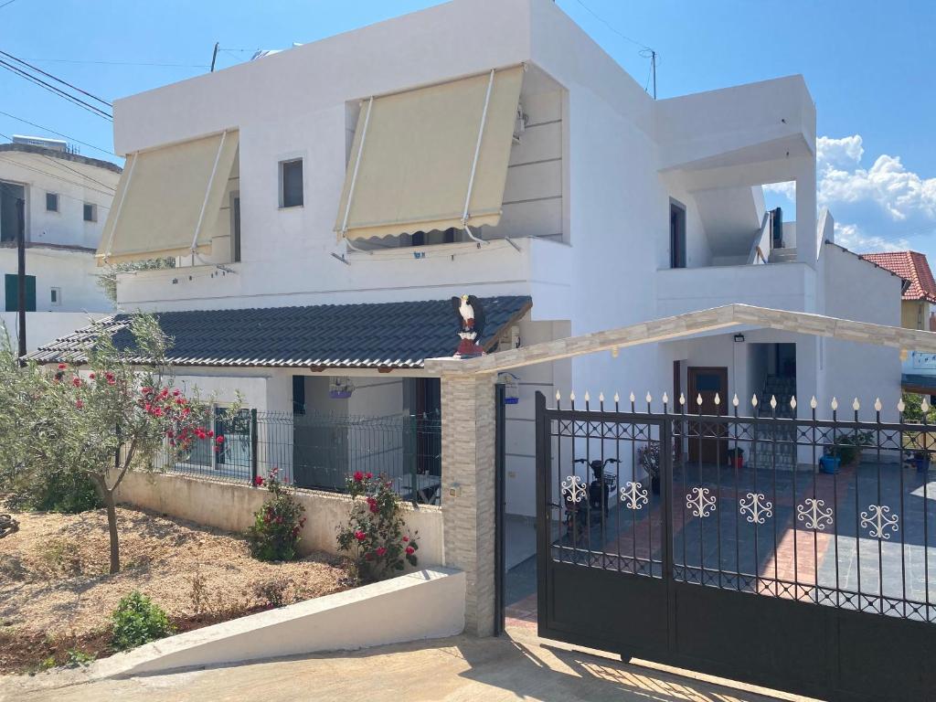 une maison blanche avec une porte noire dans l'établissement Vila Avni Likometi, à Ksamil