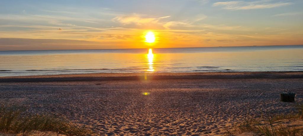 un tramonto su una spiaggia con il tramonto di 3 ruoniai a Palanga