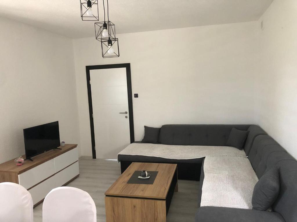 een woonkamer met een bank en een tv bij Apartman M&D in Neum