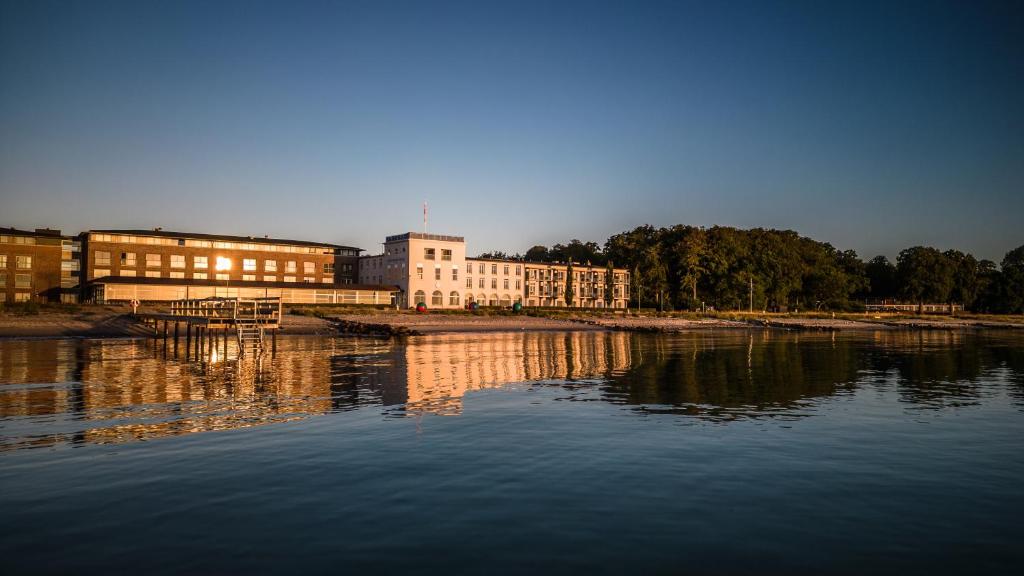 un gran edificio junto a una masa de agua en Nyborg Strand Hotel & Konference, en Nyborg